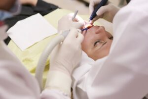 Close-up of a dentist performing a dental procedure on a patient in a clinic setting.