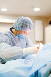 A skilled surgeon in sterile attire performing a medical procedure in an operating room.