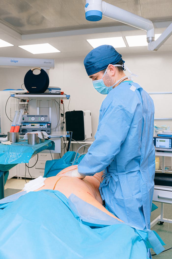 Surgeon in surgical attire performing operation in a modern operating room.