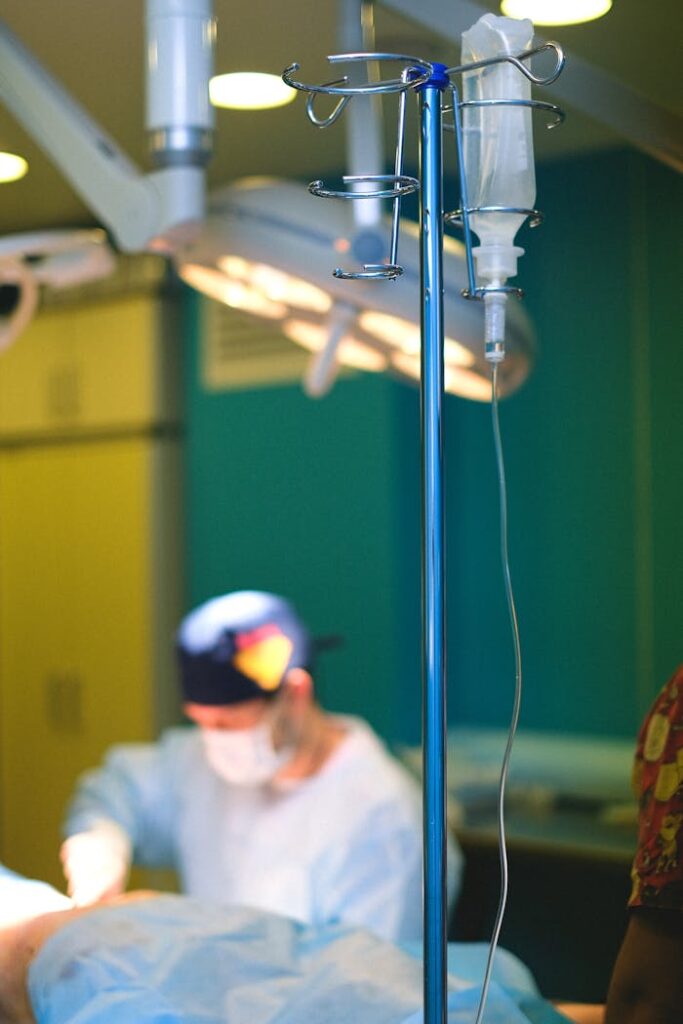 Close-up of a surgeon performing surgery in a hospital operating room with medical equipment.